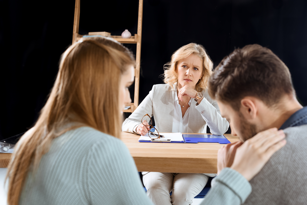 Individual speaking with a professional advisor during a sensitive consultation regarding harassment concerns and support options.